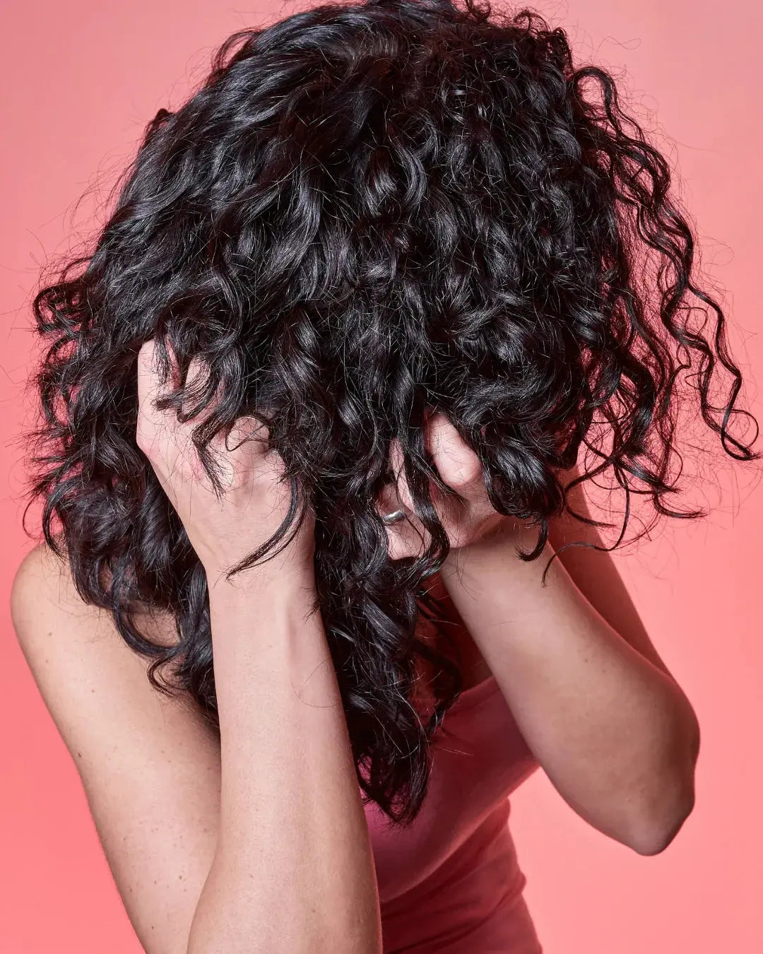 Jeune femme qui coiffe ses cheveux bien bouclés