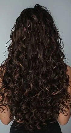 femme brune de dos avec longs cheveux bouclés