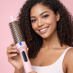 Femme avec des cheveux bouclés qui tient la brosse chauffante thermique dans ses mains